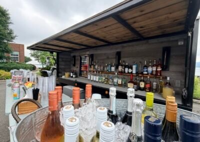 Close-up of the Shake & Stir vintage bar truck bar, stocked with wine, spirits and chilled bottles on ice at a waterfront event in Irvington NY