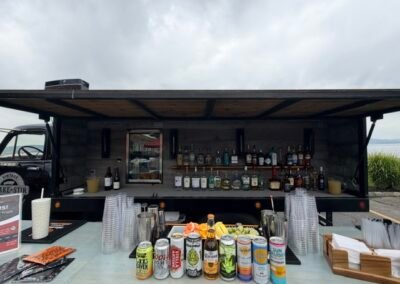 Front view close-up of the fully stocked Shake & Stir bar with craft cocktails, canned drinks, spirits and glassware, Irvington NY
